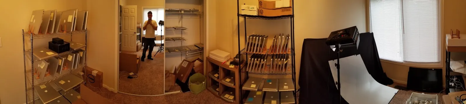 Panoramic view of a rented house room with Macs on shelves, closet storage, and a product photo setup in the next room