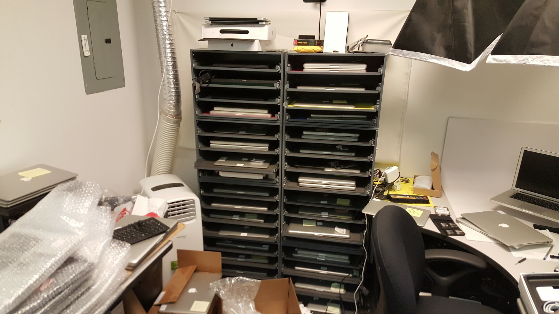 Archival photo of a rack of MacBooks being processed at TechGator