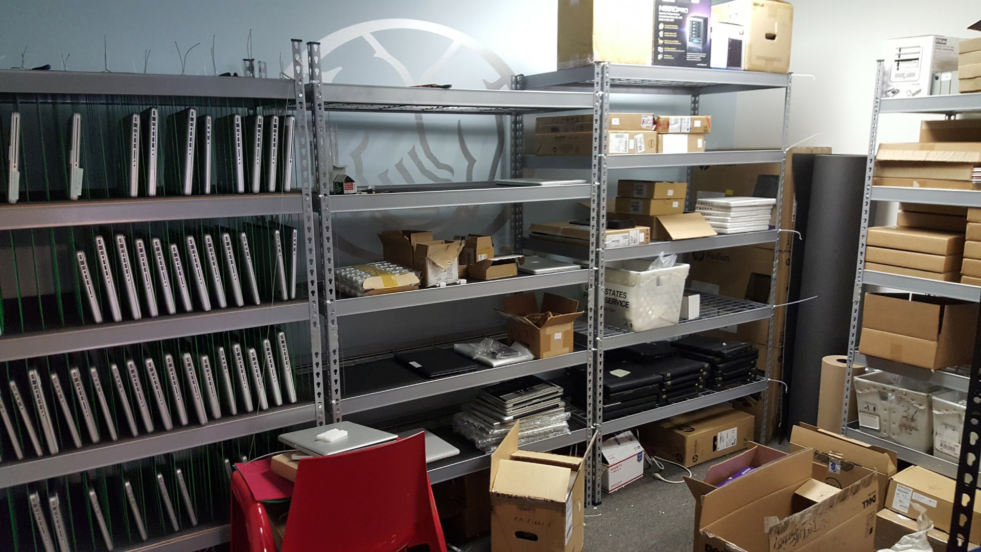 Archival photo of shelves of laptops and shipping boxes in the TechGator warehouse