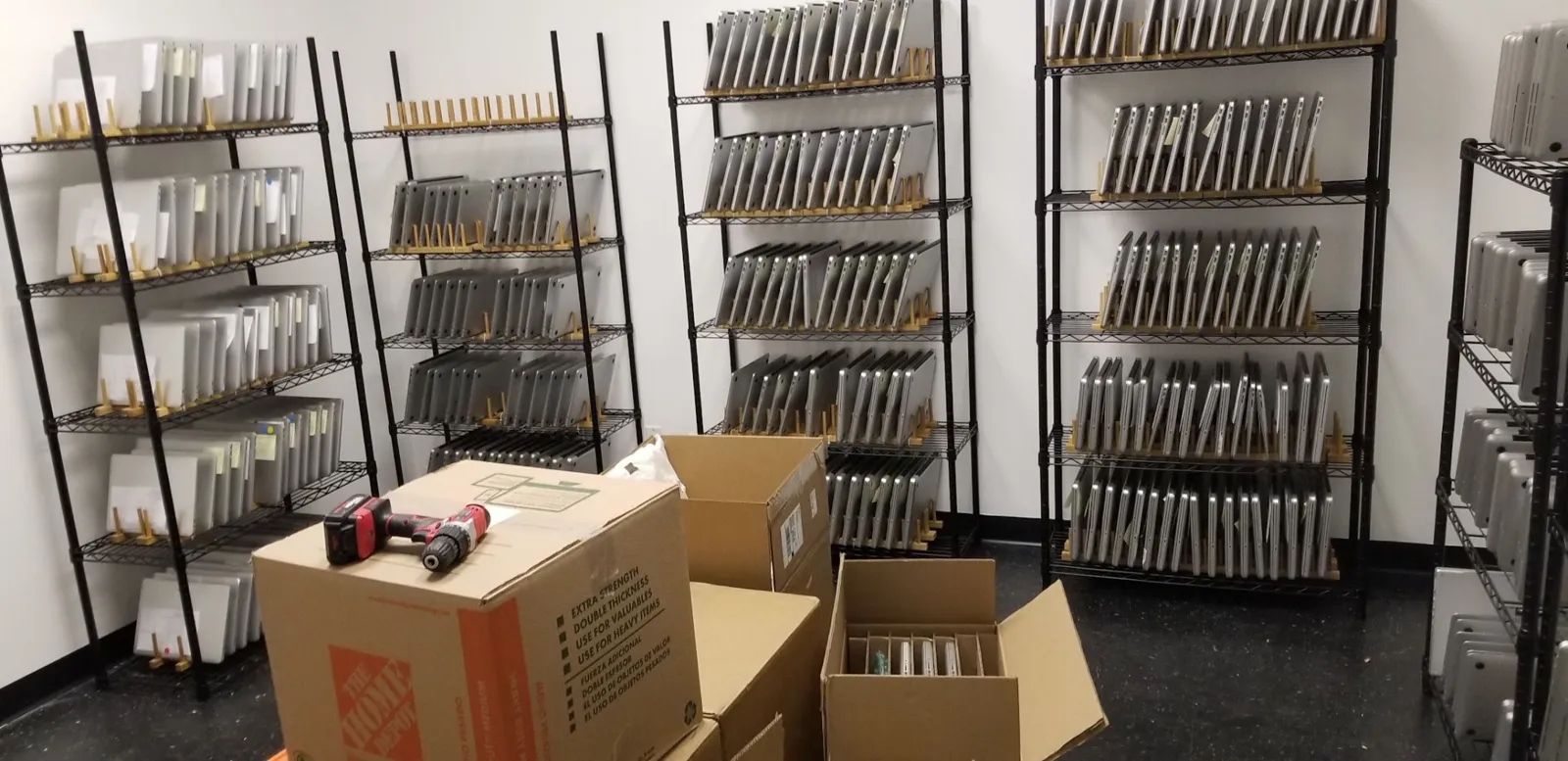 Rows of shelving filled with Macs, with moving boxes still on the floor, in the first warehouse